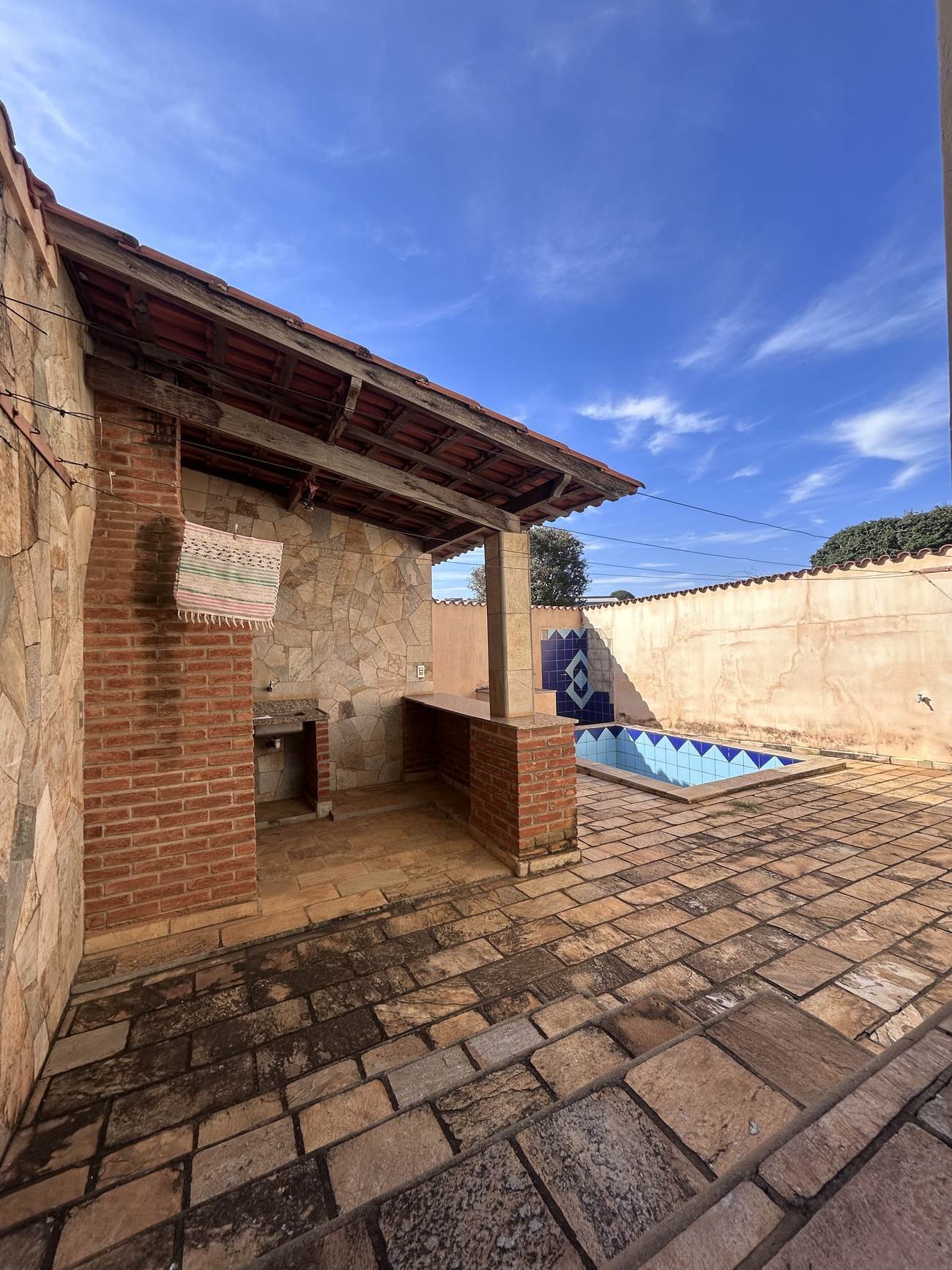 Área gourmet com churrasqueira de alvenaria e piscina